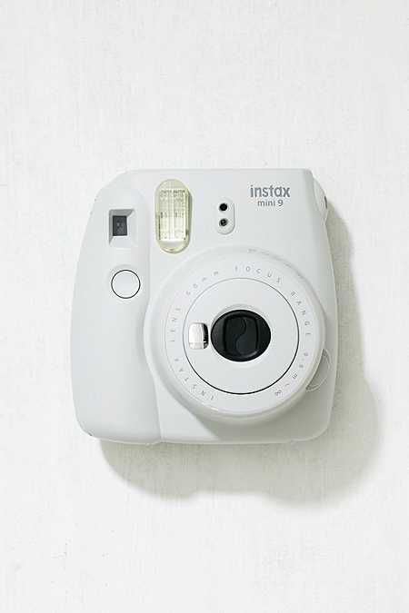 an instax camera sitting on top of a white wall