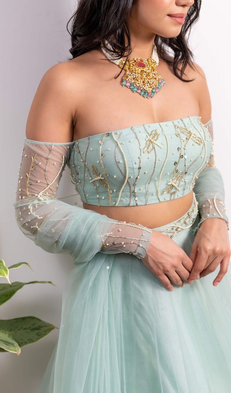 Editor's Note Off-shoulder Embroidered Blouse With Pearl Tasseled Lehenga And Dupatta Color: Green Fabric: Net, Shantoon Embroidery Details: Pearl, Sequins And Cut-dana Embroidery Care: Dry Clean Only About the Designer Founded by Silky Bindra, the couture brand under the label “Silky Bindra” is a very popular bridal wear option with chic, feminine, and elegant pieces, for any and every occasion. Festive Off-shoulder Sets For Reception, Festive Off-shoulder Reception Sets, Festive Off-shoulder Party Sets, Bollywood Style Festive Sharara With Embroidered Sleeves, Bollywood Style Sharara With Embroidered Sleeves For Festive Occasions, Fitted Off-shoulder Dress For Festive Occasions, Festive Sets With Embroidered Sleeves And Traditional Drape, Bollywood Style Sharara With Embroidered Sleeves For Wedding, Bollywood Style Embroidered Sleeves Sharara For Wedding