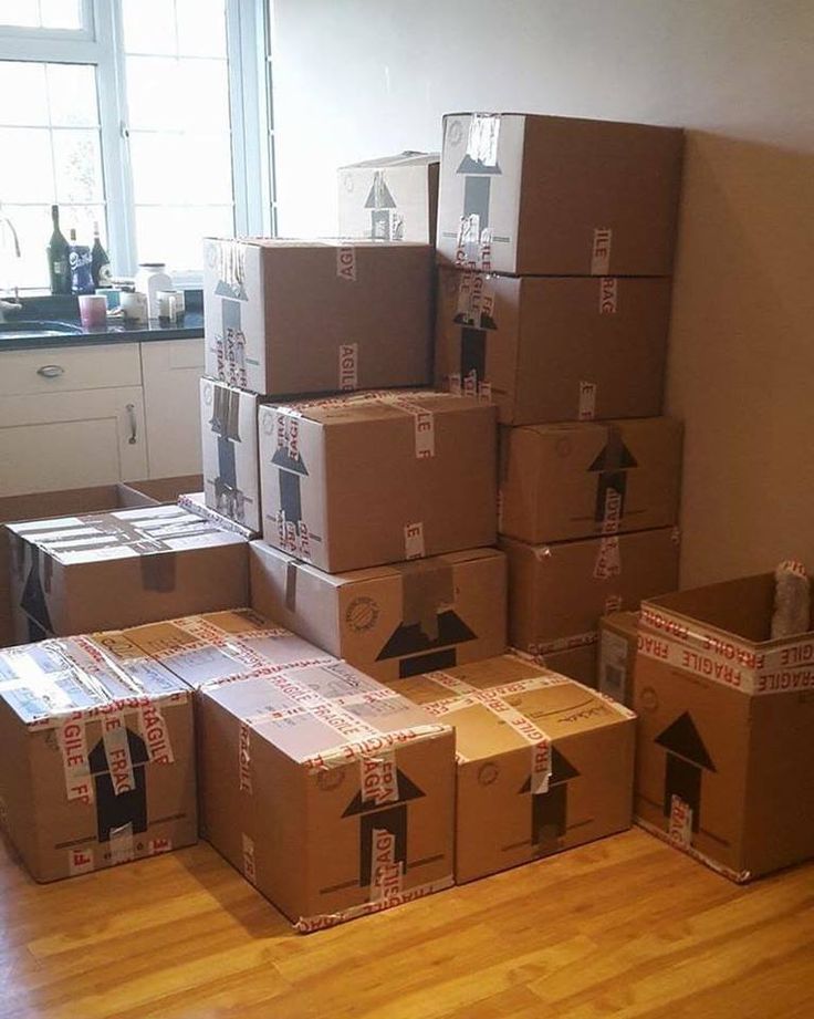 many boxes stacked on top of each other in the middle of a room with wood floors