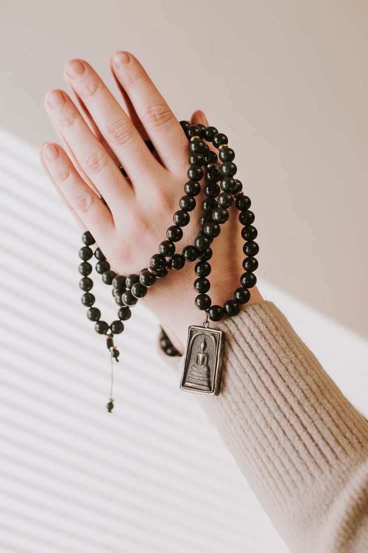 A DharmaShop exclusive 108 bead mala made from powerful, unique materials with a story! Features 108 shungite beads and a handcrafted vintage Buddha protection amulet from Thailand. Shungite is known as one of the most powerful mineral healers. It has the ability to protect and purify. Black stones like shungite are known to offer protection to the wearer, provide stability, and ground the Root Chakra. Over a decade ago, during a trade with a Tibetan artifacts collector, we received a small bag Wrist Mala, Protection Amulet, 108 Mala Beads, Buddha Image, Protection Bracelet, 108 Bead, Luck Charms, Root Chakra, Unique Materials