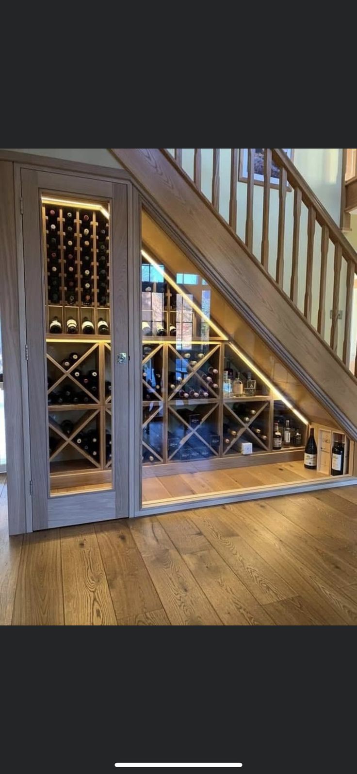 a wine cellar under the stairs in a home