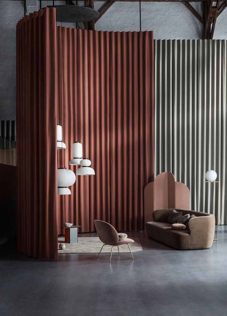 a living room filled with furniture and walls covered in vertical striped panels on the wall