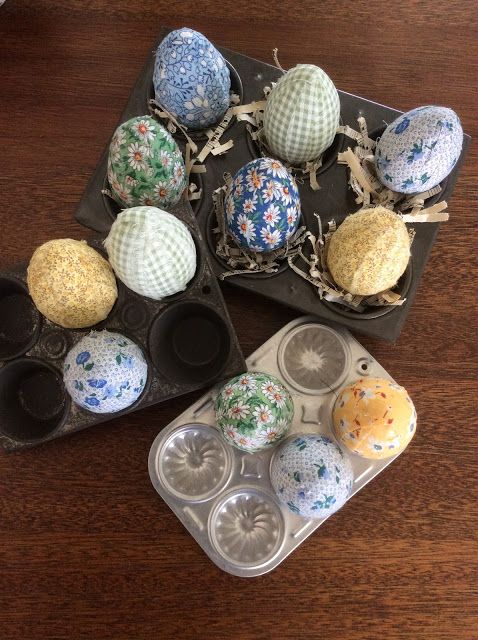 an assortment of decorated eggs in trays on a table