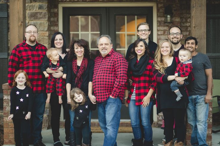 a group of people standing in front of a building with their arms around each other