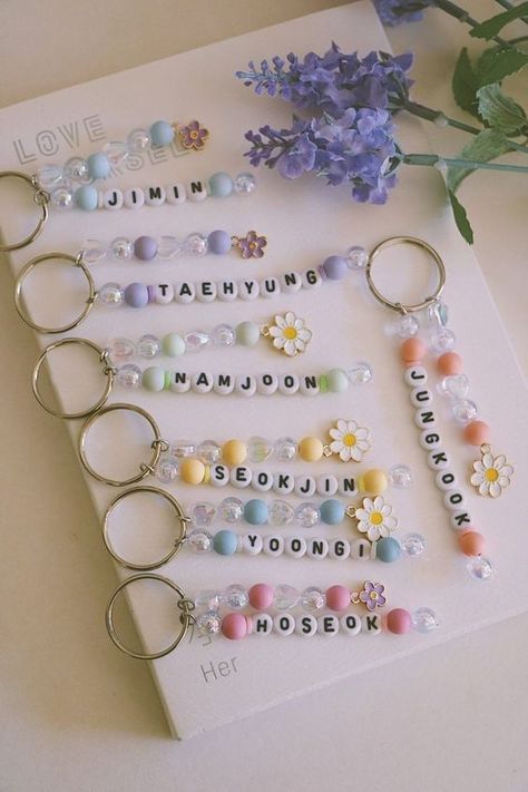 a bunch of key chains sitting on top of a white table next to some flowers