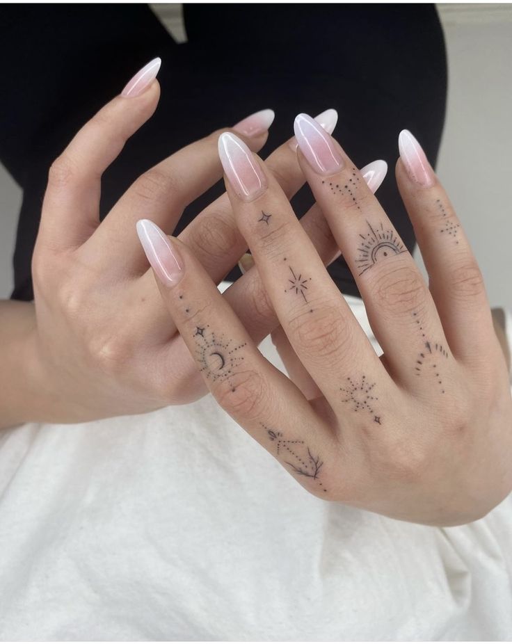 a woman's hand with tattoos on it and two fingers in the shape of stars