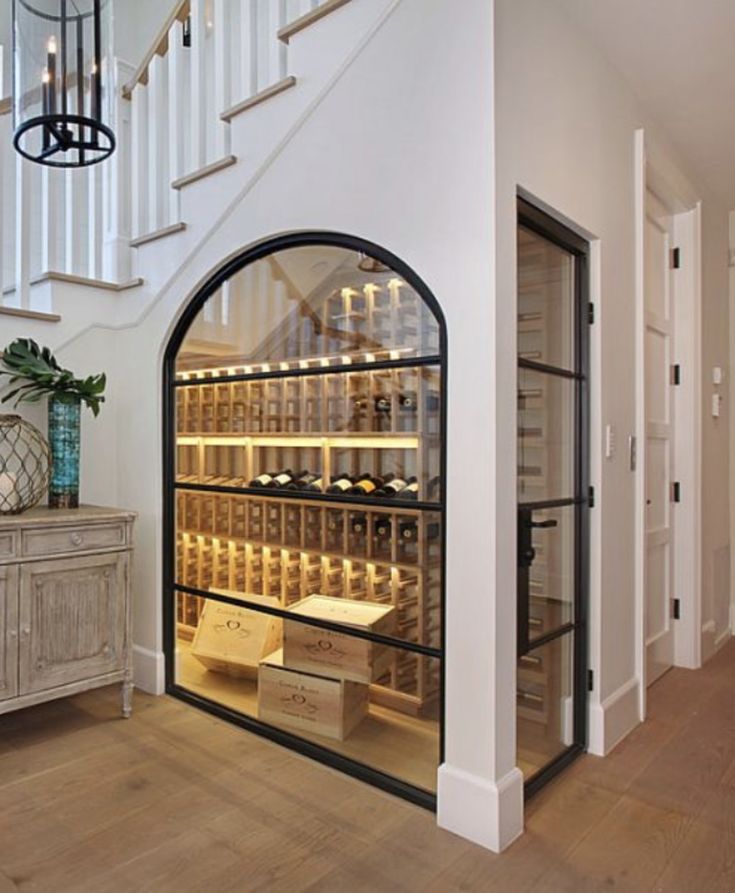 a wine cellar is shown in the entry way to a house with stairs leading up to it