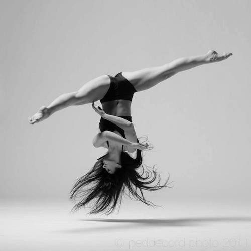 a woman is doing a handstand in the air with her legs spread out