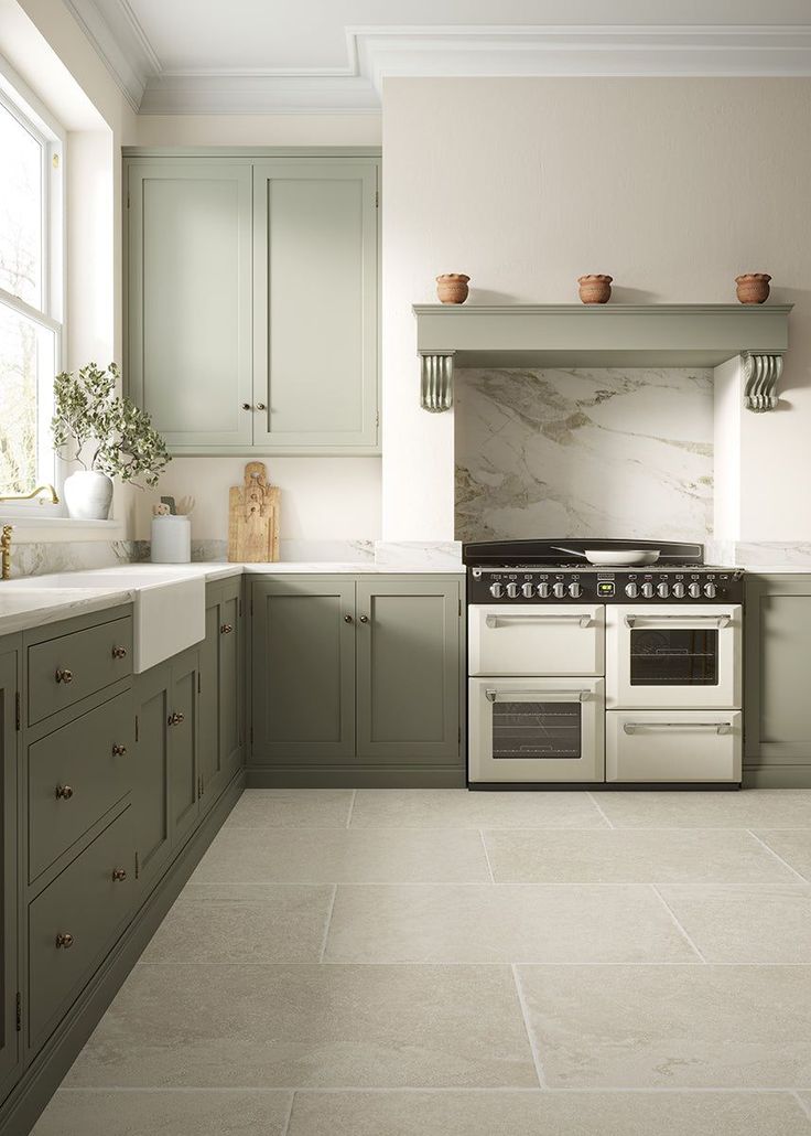 a kitchen with green cabinets and white marble counter tops, an oven in the center