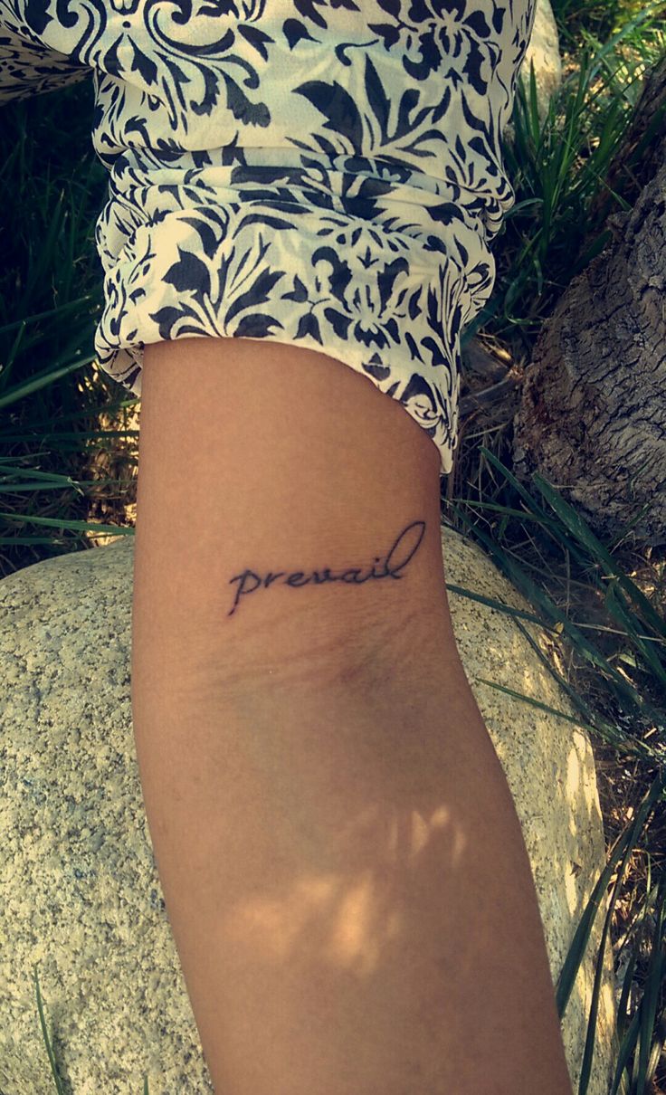 a woman's arm with the word proud tattooed on it