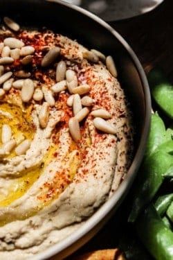 hummus with olives and sunflower seeds in a bowl