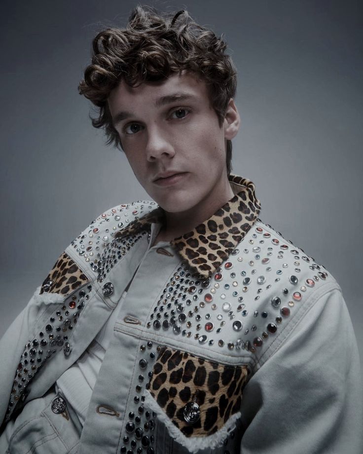 a young man in a white jacket with leopard print on the sleeves and collars