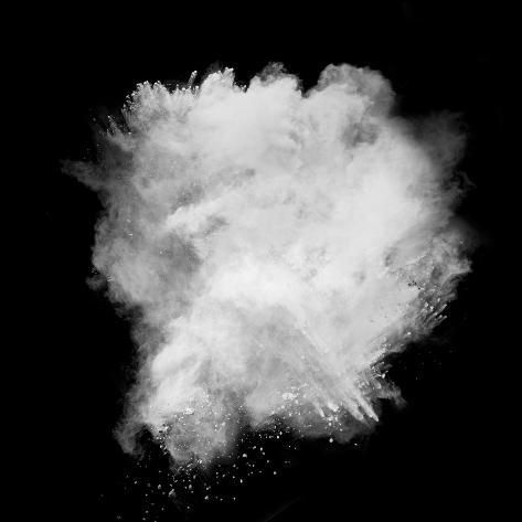 a black and white photo of powder flying in the air