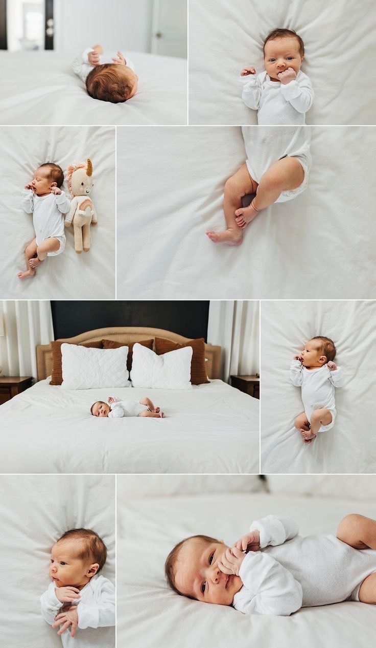 a baby laying on top of a white bed