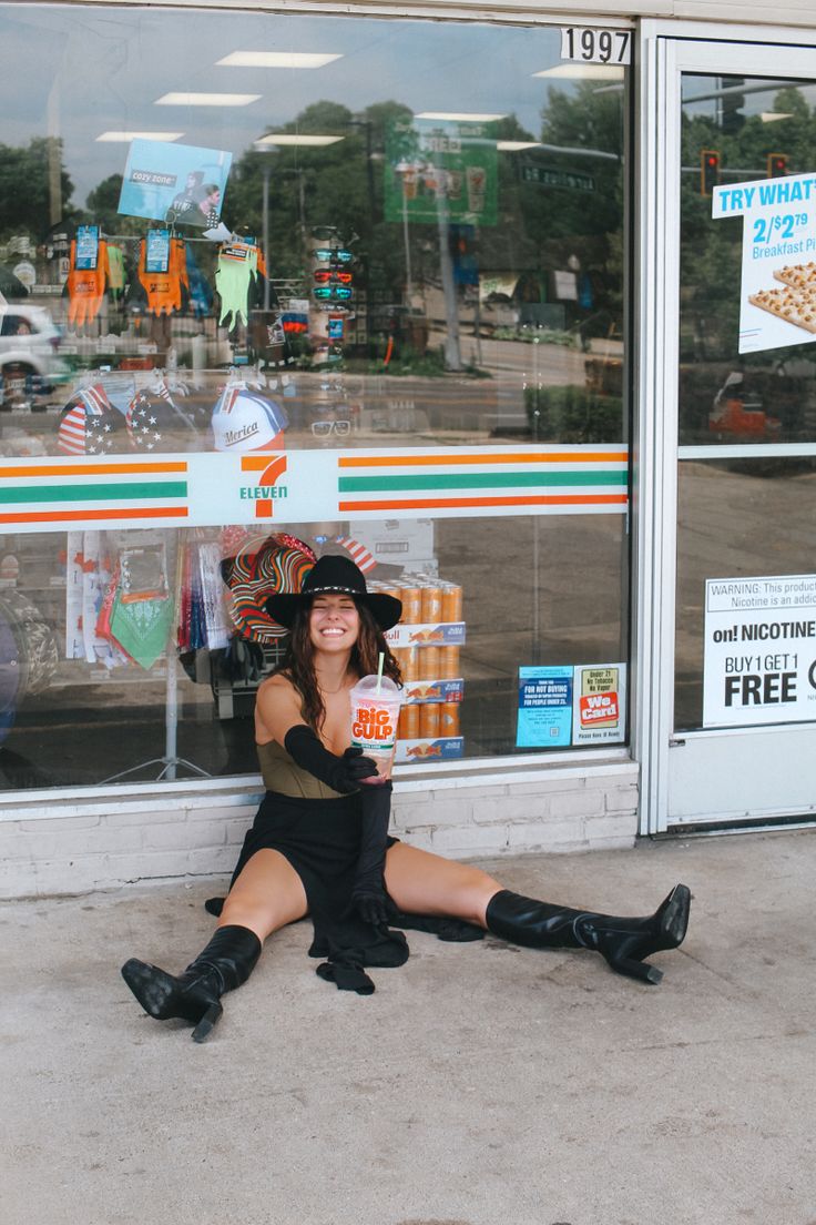 a woman sitting on the ground in front of a store