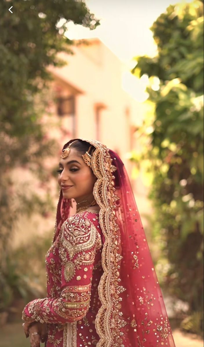 a woman in a red and gold wedding outfit