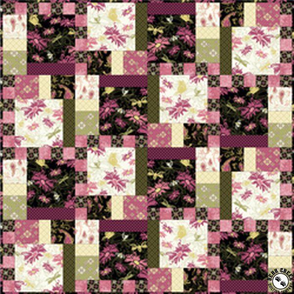 a pink and green patchwork quilt with white flowers on the center, in rows of squares