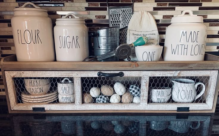 kitchen utensils and jars are displayed on a shelf