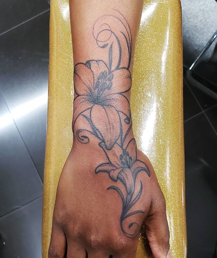 a person's hand with a flower tattoo on it