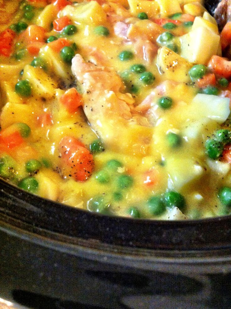 a pot filled with chicken and vegetables on top of a stove