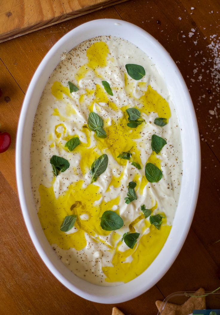 a white bowl filled with food on top of a wooden table