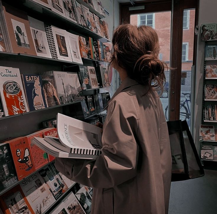 a woman is looking at books in a book store