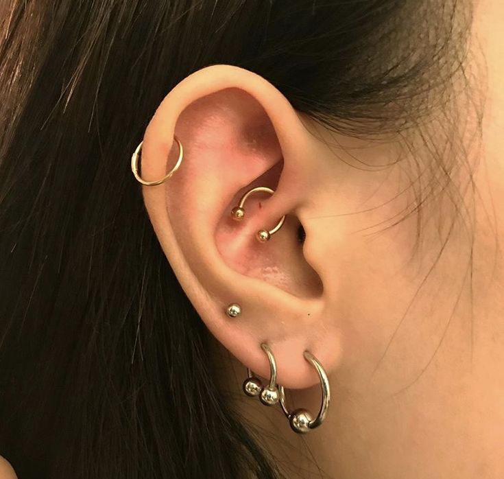 a close up of a person with ear piercings on their ears and behind the ear