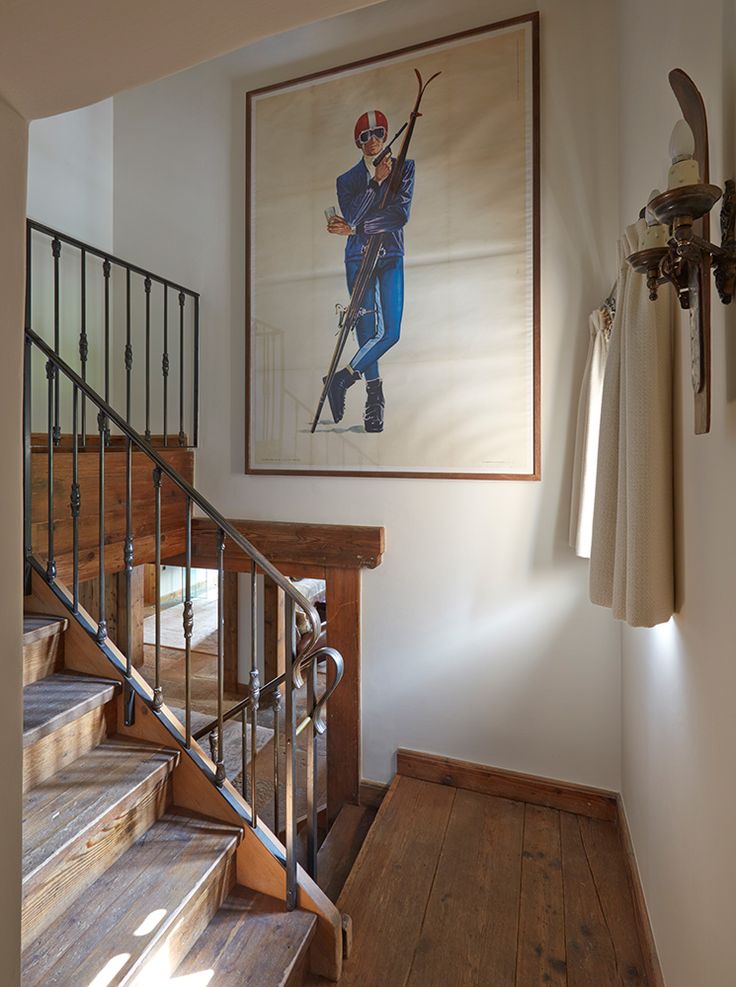 an image of a painting on the wall above a stair case in a room with wood floors