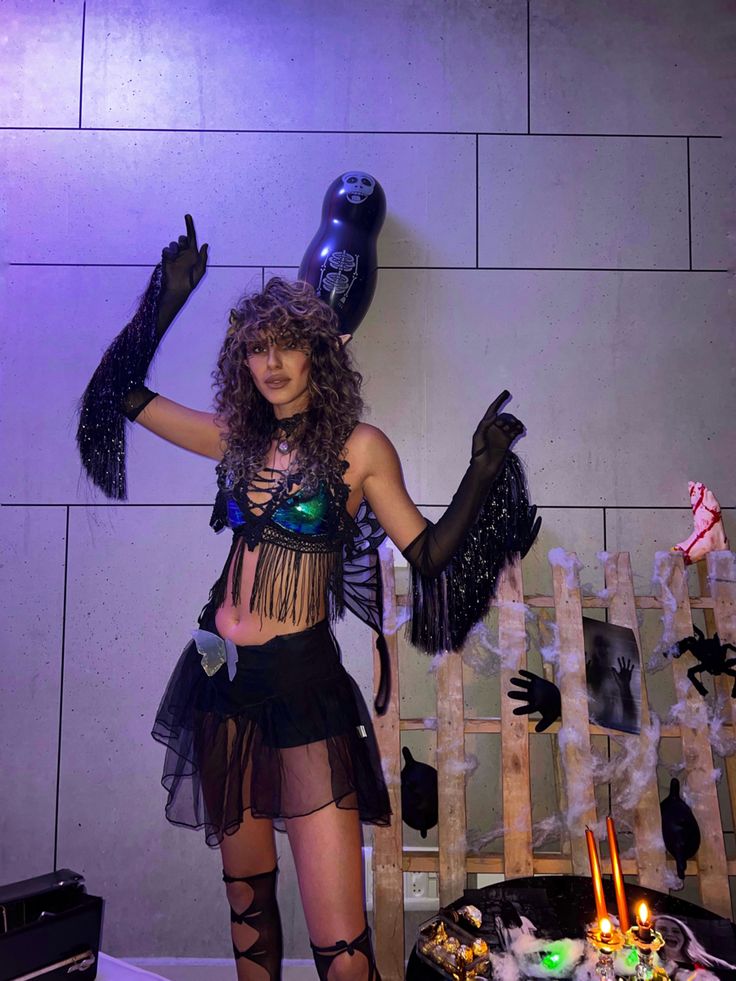 a woman dressed in costume standing next to a cake