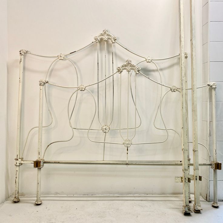 a white metal bed frame in a room