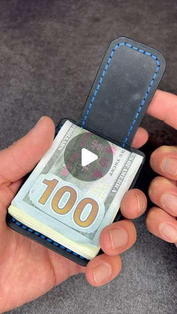 a person is holding a small wallet made out of one hundred euros bill and playing with it