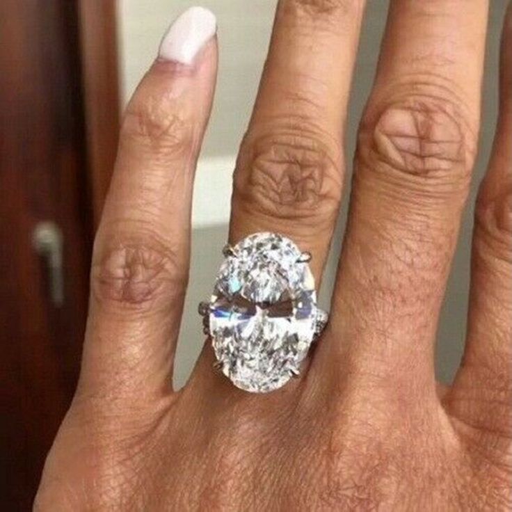 a woman's hand with a ring on it and an oval diamond in the middle