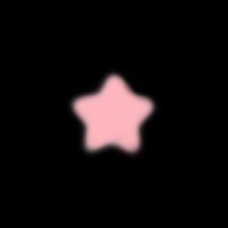 a blurry image of a pink star on a black background