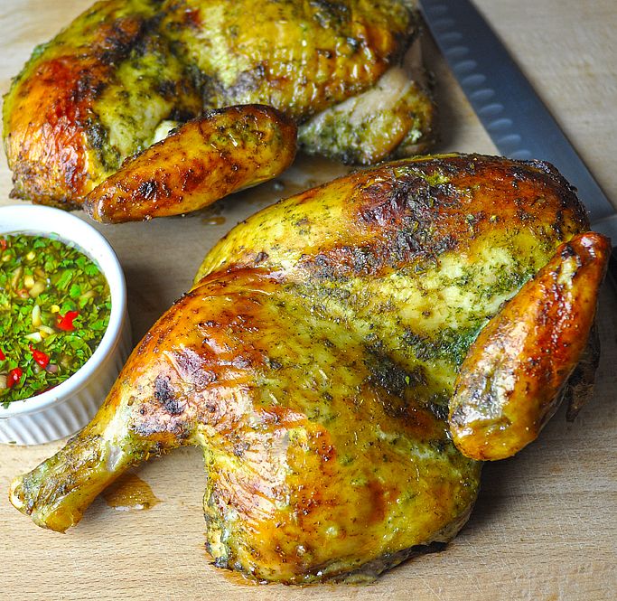 two whole chickens on a cutting board next to a bowl of salsa