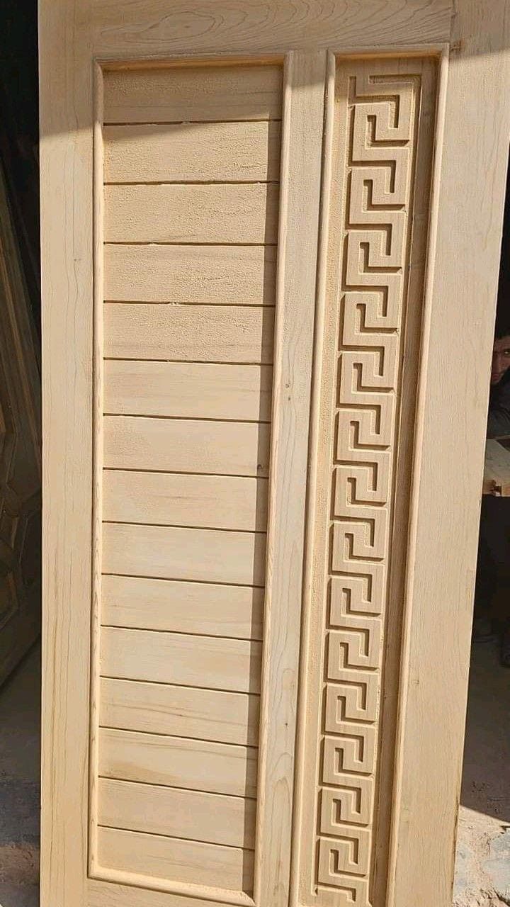 an unfinished wooden door sitting on top of a floor next to a pile of wood