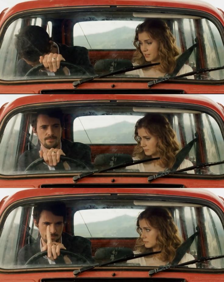 the man and woman are sitting in the red truck together looking at each other's eyes