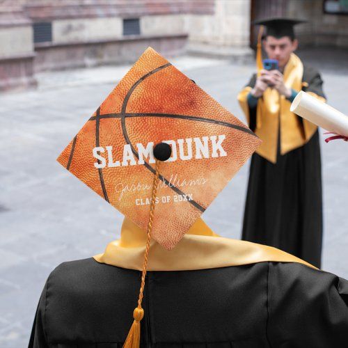 two graduates in gowns and caps are taking pictures with their cell phones while one holds a diploma