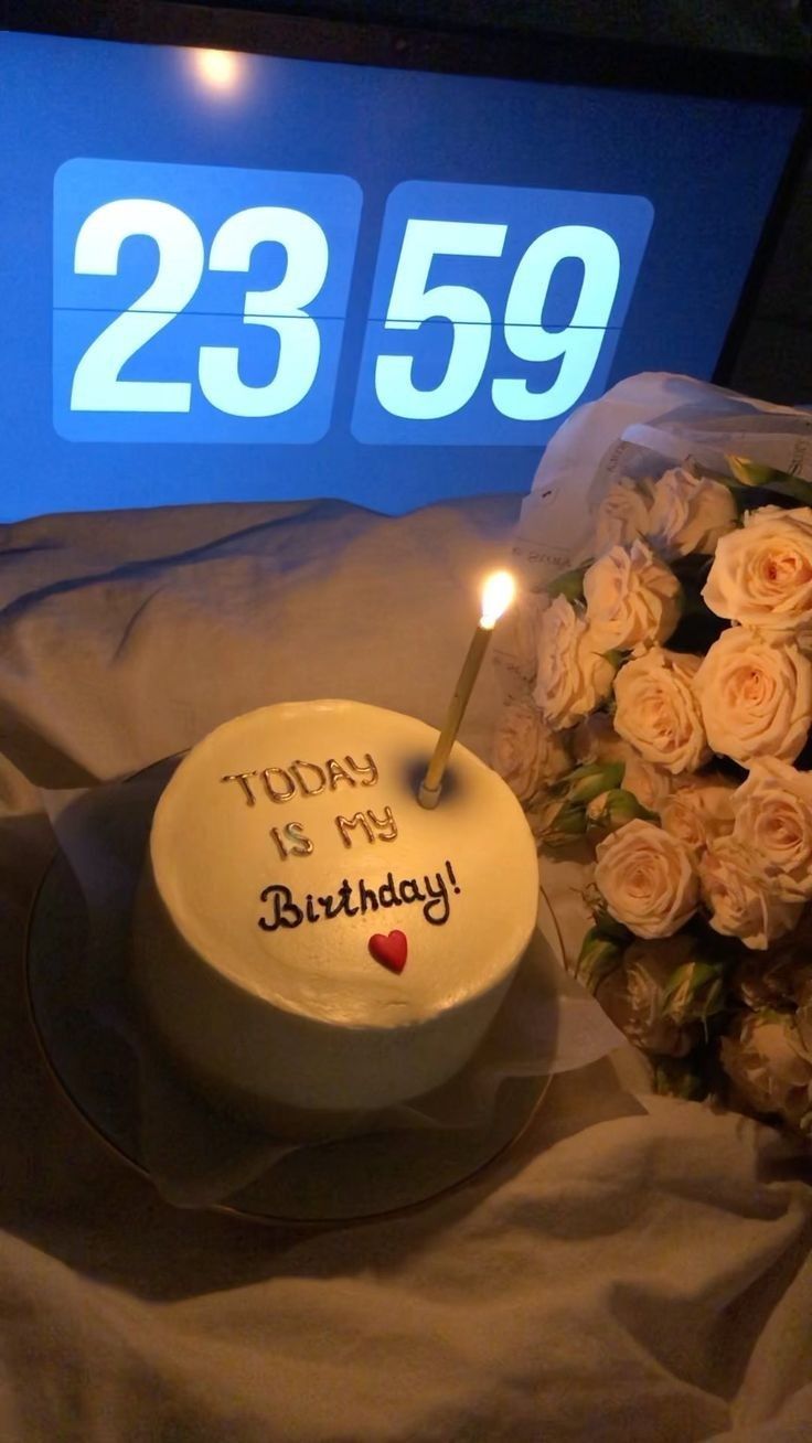 a birthday cake with candles and flowers on a table next to a sign that says happy birthday 2239