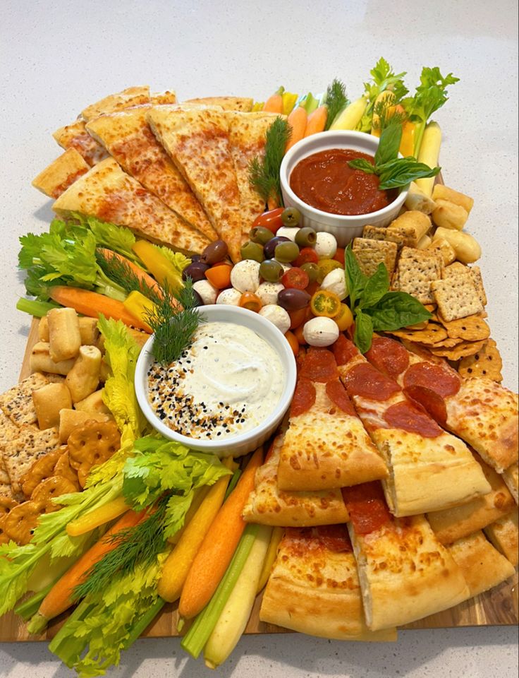 a pizza platter with many different types of food on it and dipping sauces