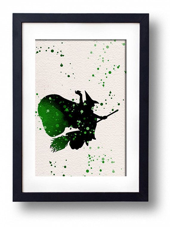 the silhouette of a witch flying through the air with green paint splattered on it