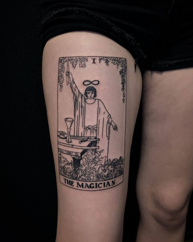 a woman's leg with a tarot card tattoo on her left side thigh