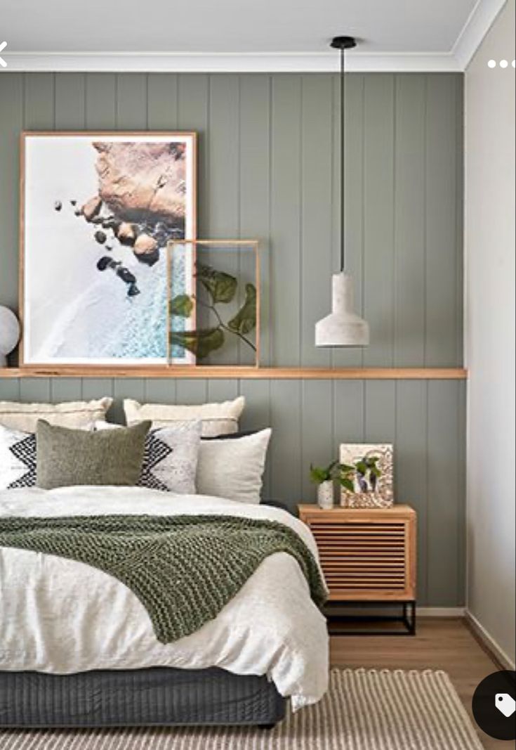 a bed sitting in a bedroom next to a wooden shelf filled with pictures on the wall