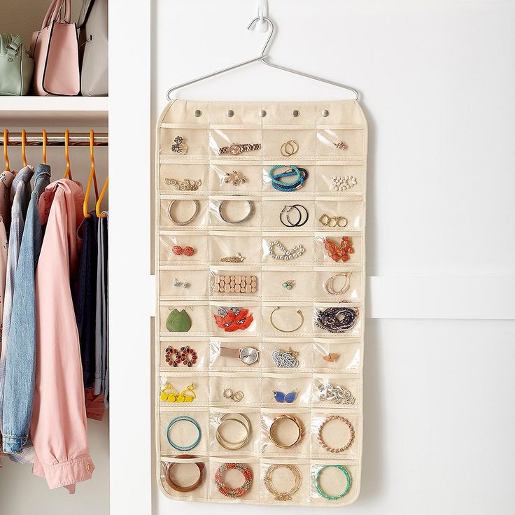 a white closet filled with lots of different types of rings and bracelets on hangers