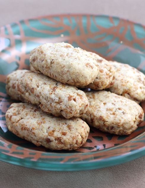 some cookies are stacked on top of each other in a blue bowl with orange and pink designs