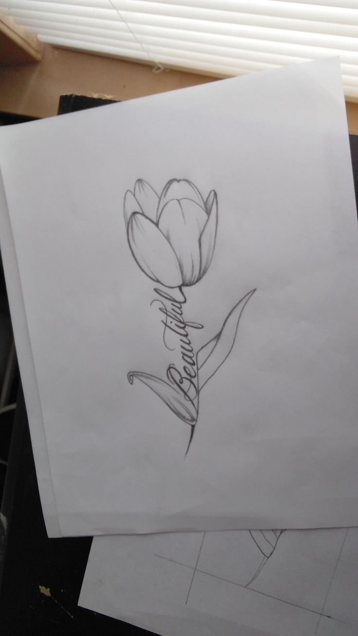 some drawings are on top of paper and one has a drawing of a flower in the middle