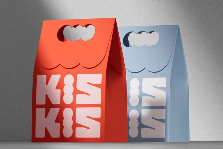 two paper bags with the words kiss kiss on them are sitting next to each other