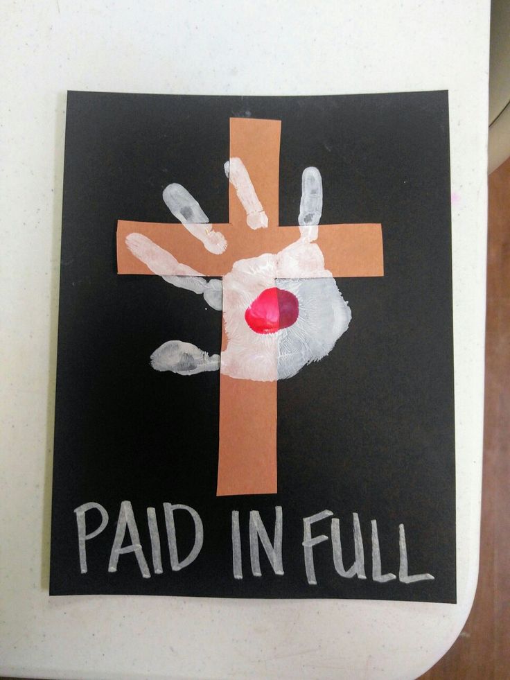 a cross with handprints painted on it and the words paid in full written below