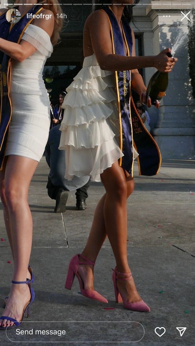 two women dressed in white are walking down the street