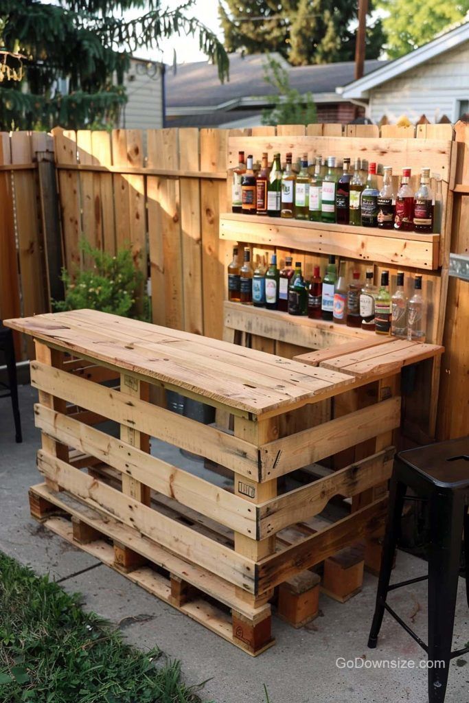 an outdoor bar made out of pallets and wooden crates with bottles on the top