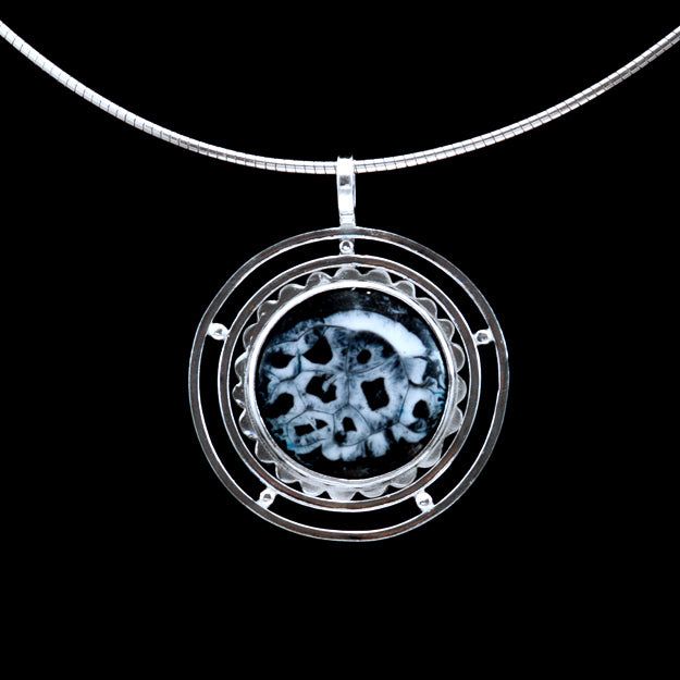 Solar Eclipse is a handmade, black gray and white enamel pendant necklace set in fine silver Adjustable Black Enamel Jewelry, Collectible Metal Jewelry With Round Pendant, Collectible Round Pendant Metal Jewelry, Collectible Metal Round Pendant Jewelry, Custom Round Sterling Silver Necklace With Polished Finish, Polished Enamel Medallion Jewelry, Modern Round Jewelry With Unique Variations, Sterling Silver Necklace With Large Pendant And Snake Chain, Modern Round Collectible Jewelry